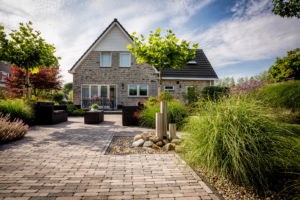 sierbestrating en tuinverlichting toegepast bij de zithoek die tevens als terras dient in een droomtuin gelegen bij een vrijstaande woning omgeven door borders met siergras en vaste bomen en stuiken in Oudewater en Linschoten. Tevens ook werkzaam in de regio Haastrect en Bodegraven